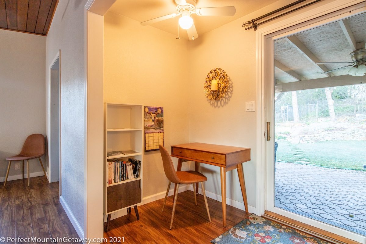 A tidy interior room with a desk, chair, and bookshelf.